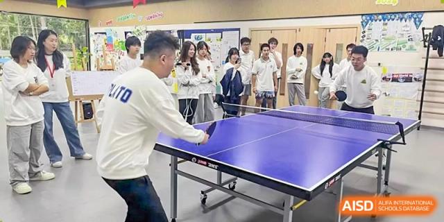 A student focuses on his form while playing a game of ping pong during an indoor sports session at Griffin International Academy.