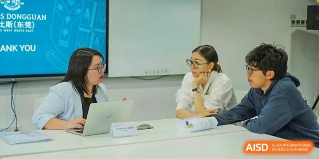 Two female educators in a bright office space engage in a collaborative professional discussion while working together on a laptop at St Bees Dongguan.