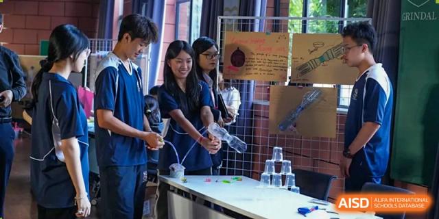 Students collaborate on a physics or engineering project involving plastic bottles and tubes in a well-equipped school workshop at St Bees Dongguan.