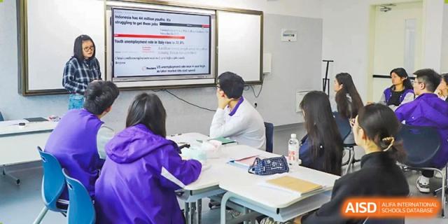 A teacher presents a lesson on an interactive whiteboard to students in a bright classroom at Beijing No. 35 High School International Department.