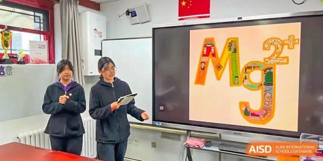 A student leads a class presentation using a large digital display in a modern classroom at Beijing No. 35 High School International Department.