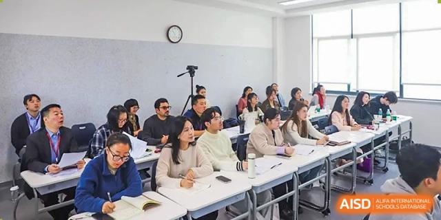 Students and visitors listen to a lecture in a tiered university-style seminar hall at Beijing No. 35 High School International Department.