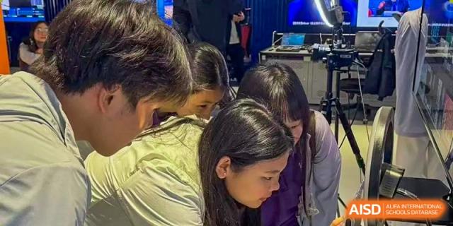 Students huddle together to view a project on a digital screen during an interactive workshop at Beijing No. 35 High School International Department.
