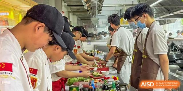 Students in a kitchen setting work together to prepare food during a culinary arts class at Beijing No. 35 High School International Department.