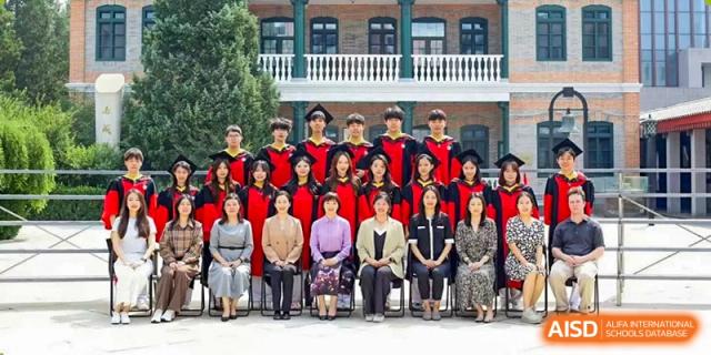 A large group of graduates and faculty members poses for a formal commemorative photo on campus at Beijing No. 35 High School International Department.