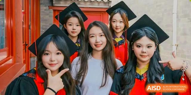 Three female graduates smile for a close-up portrait during their graduation ceremony at Beijing No. 35 High School International Department.