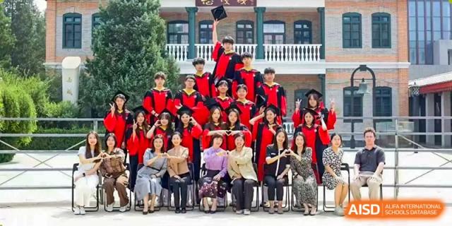 Students in graduation regalia throw their caps into the air in celebration on the school steps at Beijing No. 35 High School International Department.