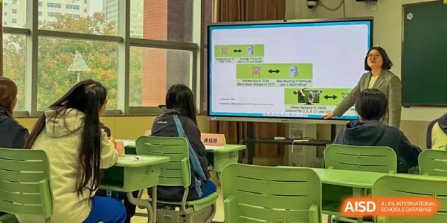 A student sits at her desk in a quiet classroom while looking at an educational presentation on a screen at Beijing No. 35 High School International Department.