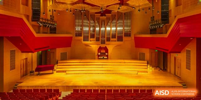 A grand concert hall features a massive pipe organ and rows of red seating at Beijing No. 35 High School International Department.