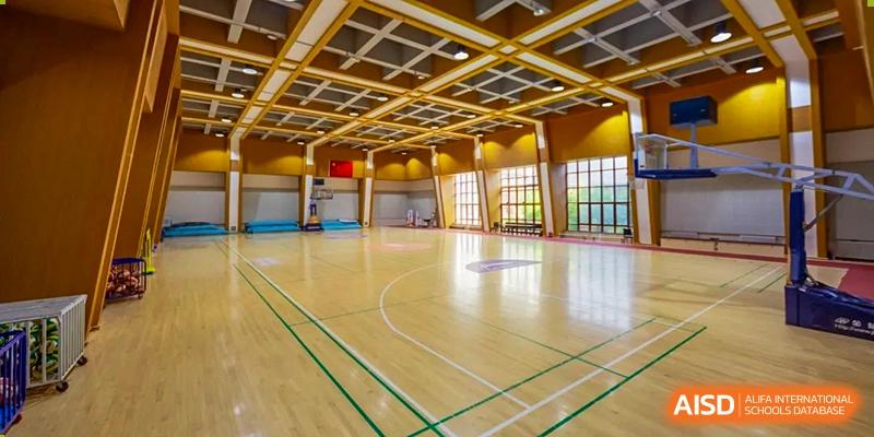 A modern indoor gymnasium features polished wood floors and professional basketball hoops at Beijing No. 35 High School International Department.