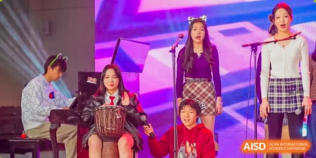 A student band featuring a drummer and singers performs under professional stage lights at Beijing No. 35 High School International Department.