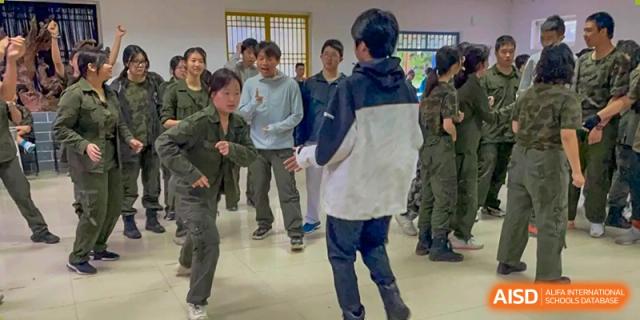Students participate in a group coordination exercise during an indoor physical training session at Beijing No. 35 High School International Department.