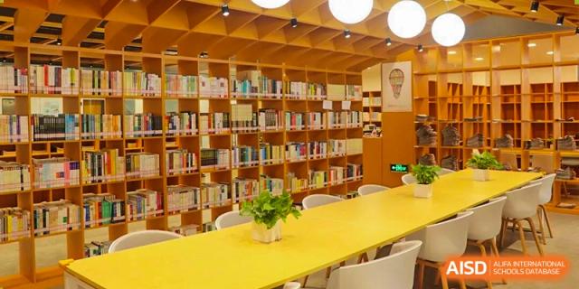 A bright and modern school library interior with neatly arranged bookshelves, long study tables, and a calm atmosphere designed for focused learning at Xiamen ITG-SUIS High School