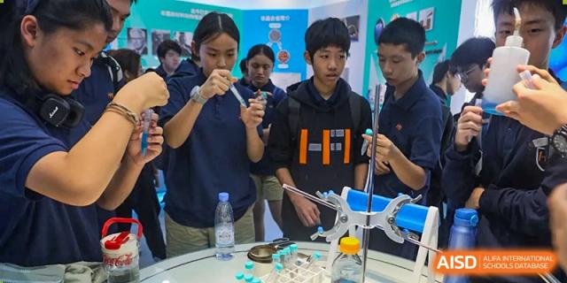 A group of students conducts a chemistry experiment at a laboratory station, carefully using pipettes and test tubes at Huafu International Department.