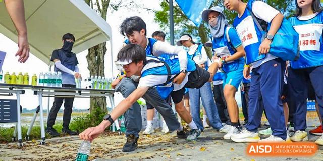 Students engaged in a physical team-building challenge outdoors, showing focus and physical coordination at the Huafu International Department.