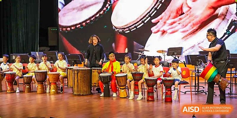 Students perform a traditional drum routine on stage during a cultural school event at TEDA International School Tianjin.