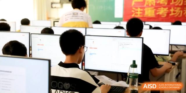 Students sitting at computers in a classroom, looking at screens and engaging in digital learning tasks to develop their technical proficiency at Ronghaui International School.