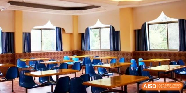 A spacious, clean school cafeteria with organized tables and chairs, ready to serve meals to students in a comfortable setting at Ronghaui International School.
