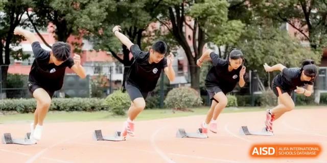 Young athletes practicing their starting block technique on a running track, preparing for a track and field competition at Ronghaui International School.