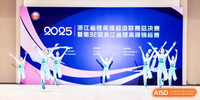 Rhythmic gymnasts performing a coordinated routine with ribbons on a blue stage during a championship event at Ronghaui International School.