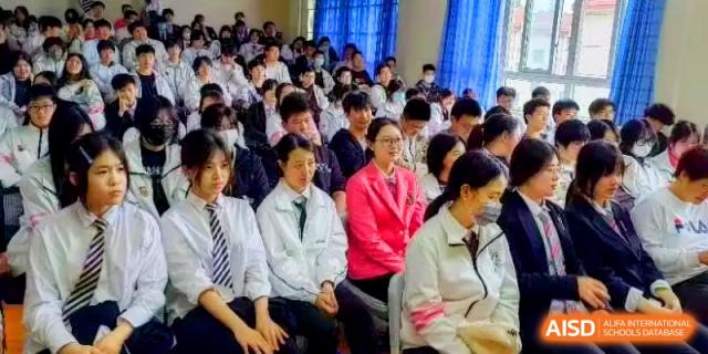 A close-up view of students and staff sitting together during an assembly or presentation at Shanghai Gold Apple Bilingual School.