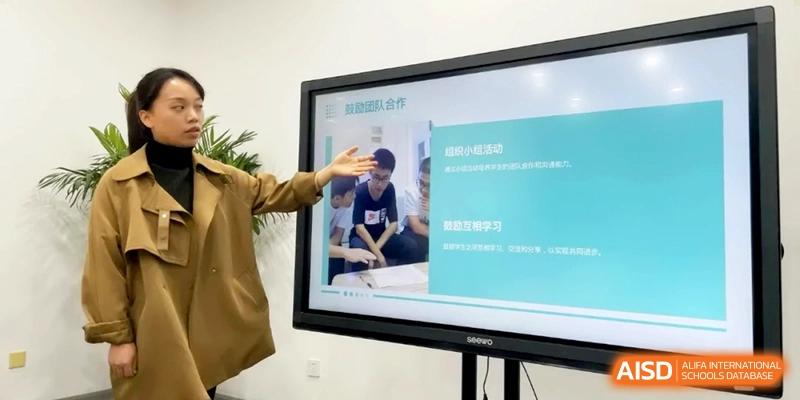 An instructor points to an interactive digital screen during a multimedia presentation at Shanghai Gold Apple Bilingual School.