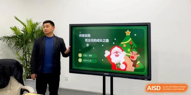 A teacher presents a Christmas-themed slide on a digital screen to a class at Shanghai Gold Apple Bilingual School.