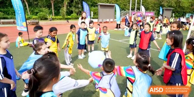 Young children play with a large inflatable ball during an outdoor sports day event at Shanghai Gold Apple Bilingual School.
