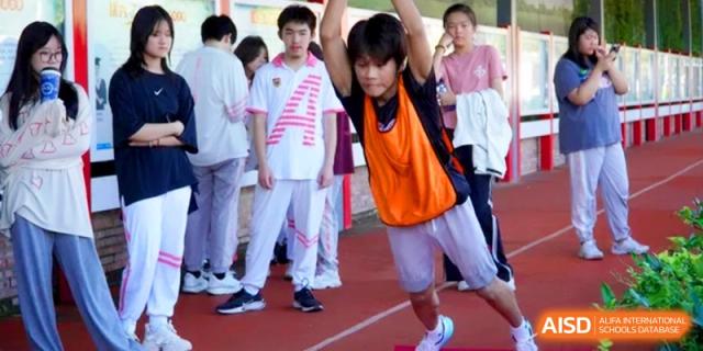 A student in an orange vest prepares for a track and field event at Shanghai Gold Apple Bilingual School.