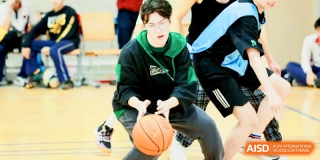 A student focuses on dribbling a basketball during a sports match at Shanghai Gold Apple Bilingual School.