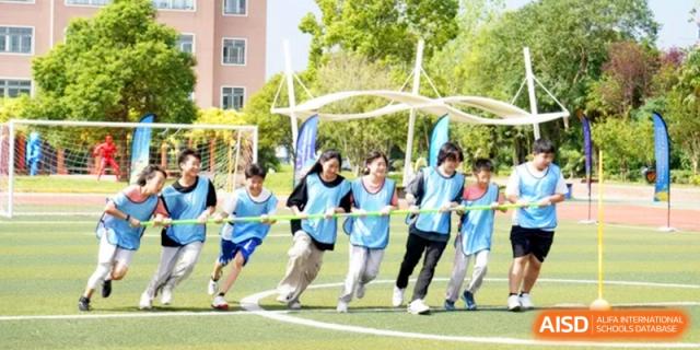 A group of students runs together during a team-building exercise at Shanghai Gold Apple Bilingual School.