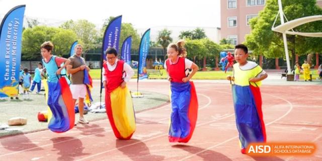 Students compete in a colorful sack race on the school sports field at Shanghai Gold Apple Bilingual School.