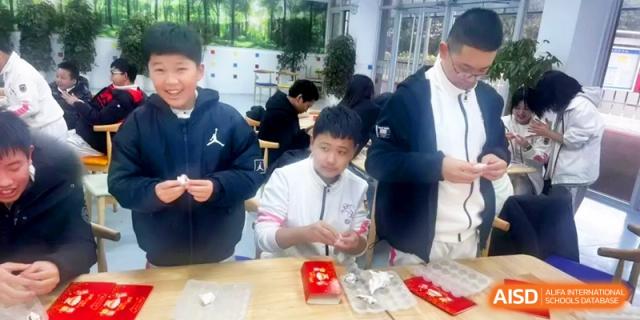 Three young students smile while learning how to shape traditional treats during a class at Shanghai Gold Apple Bilingual School.