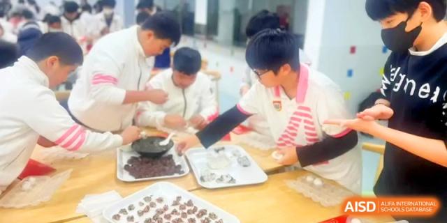 Students focus on preparing trays of ingredients for a hands-on culinary lesson at Shanghai Gold Apple Bilingual School.