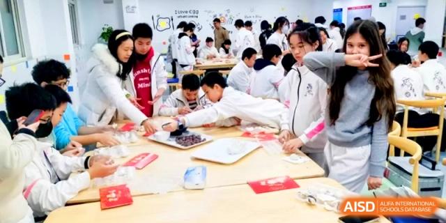 Many students participate in a collaborative food-making workshop in a bright classroom at Shanghai Gold Apple Bilingual School.