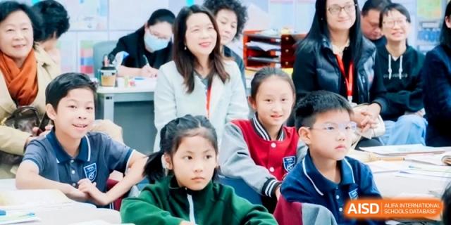 Young students sit in a classroom setting, listening intently to a lesson or presentation at Shanghai Qingpu World Foreign Language High School.