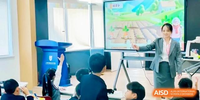 A student raises their hand to answer a question while looking at a digital screen at Shanghai Qingpu World Foreign Language High School.