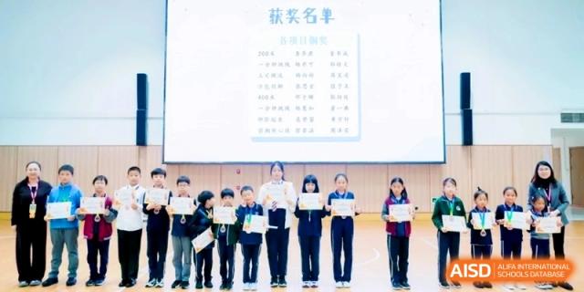 A row of students standing on a stage holding certificates of achievement during a school event at Shanghai Qingpu World Foreign Language High School.