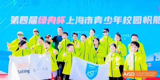 Students in neon green jackets holding a school flag during an outdoor athletic competition at Shanghai Qingpu World Foreign Language High School.
