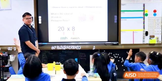 Students participate in a math lesson involving currency conversion shown on a digital screen at Shanghai United International School, Hongqiao Campus.
