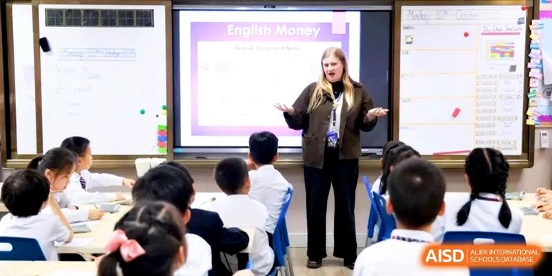 An educator leads an engaging English lesson about money using a large interactive whiteboard at Shanghai United International School, Hongqiao Campus.