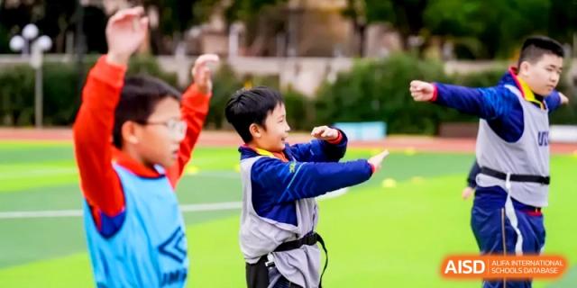 Young students in athletic wear practice their throwing and coordination skills during a physical education class at Shanghai United International School, Hongqiao Campus