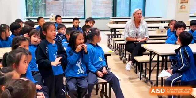Young students in blue uniforms sitting together during an outdoor activity at Shanghai United International School, PudongYoung students in blue uniforms sitting together during an outdoor activity at Shanghai United International School, Pudong