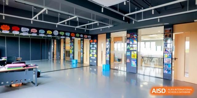 Modern open-plan classroom with colorful displays and blue seating cubes at Shanghai United International School, Pudong