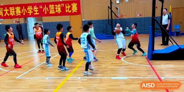 Young athletes compete in an energetic basketball game on an indoor court during a sports event at Shanghai United International School, Pudong