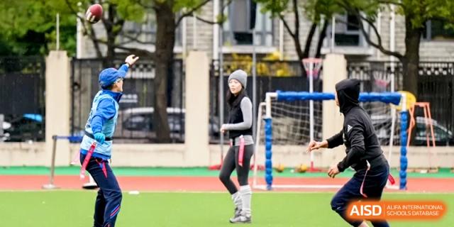 A student athlete stands on a green turf field ready for a sports activity during a physical education lesson at Shanghai United International School, Pudong