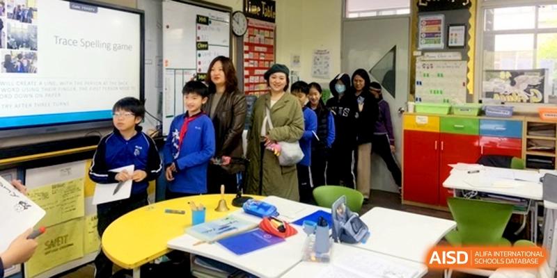 Parents and students gathering near a yellow table in a bright classroom at Shanghai United International School, Shangyin Campus.