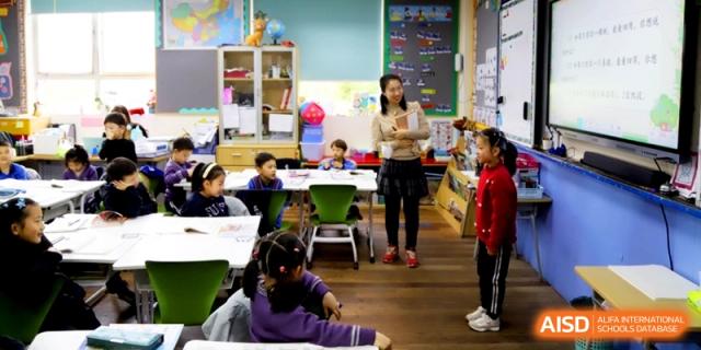 A teacher standing in a classroom while students sit at their desks at Shanghai United International School, Shangyin Campus.