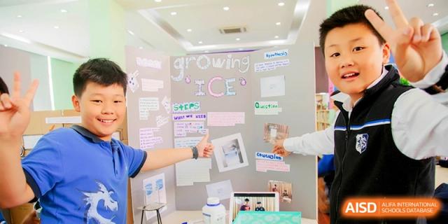 Students presenting a science project board titled Growing Ice during a school exhibition at Shanghai United International School, Shangyin Campus.