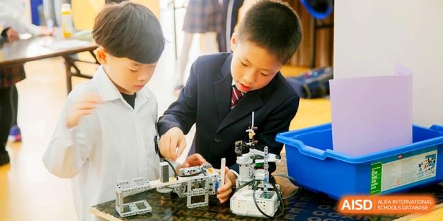Two students collaborating on a complex robotics and engineering project during a STEM class at Shanghai United International School, Shangyin Campus.